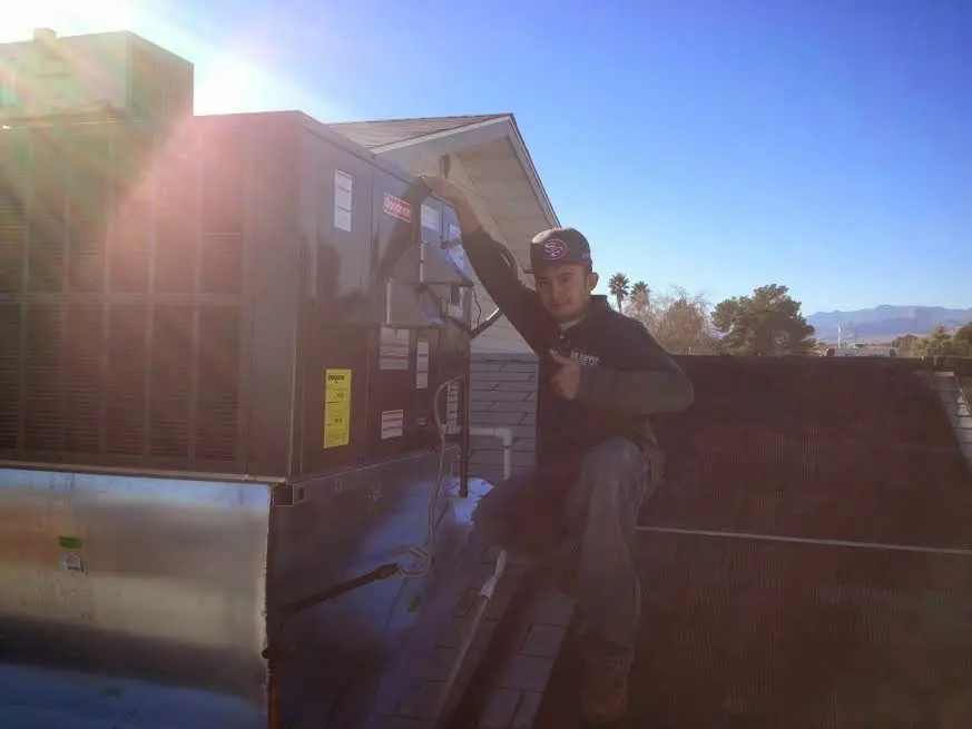 HVAC technician performing Air Duct Repair on a rooftop unit in Palatine